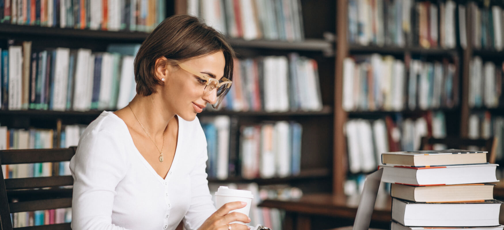 mujer leyendo la pantalla en una biblioteca